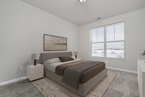 A bedroom with a large bed and a painting on the wall.