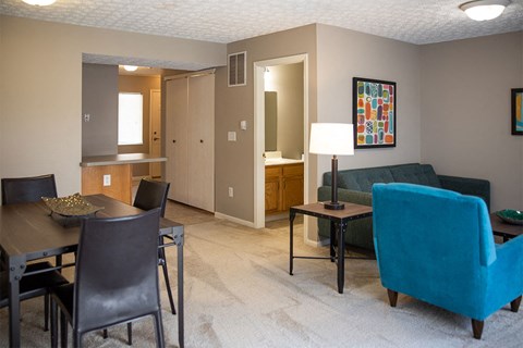 A living room with a dining table and chairs.