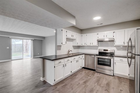 A kitchen with white cabinets and appliances.