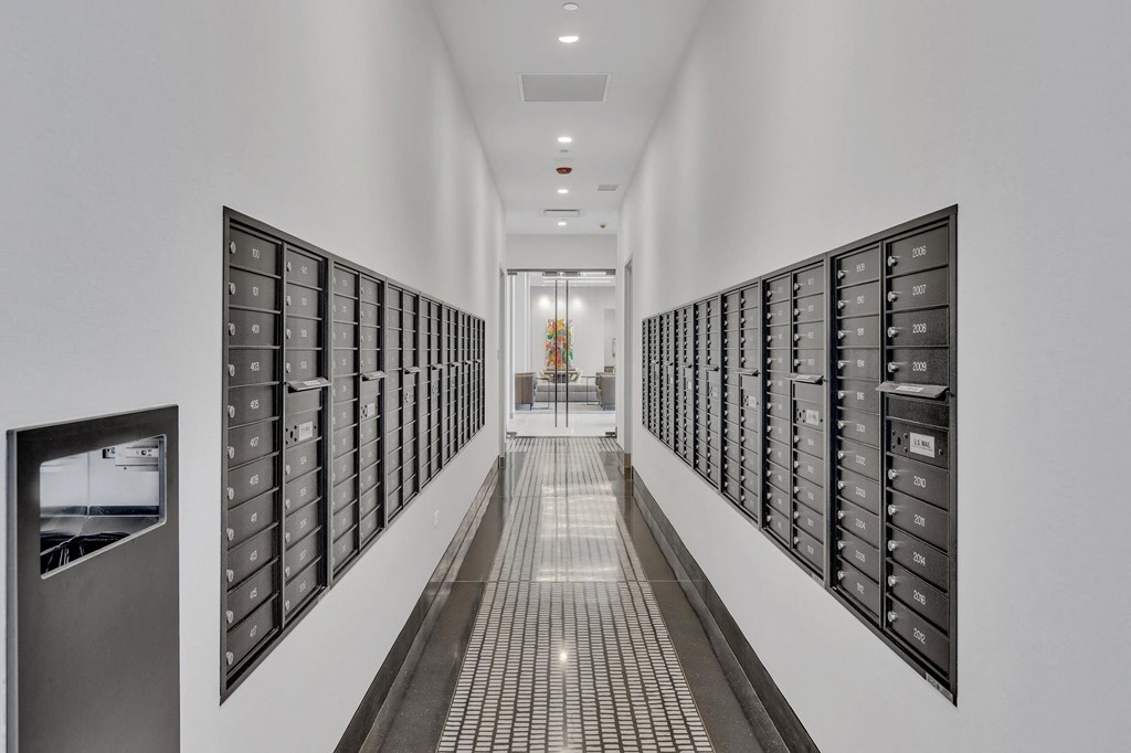 a long hallway with filing cabinets in a white room with a glass door