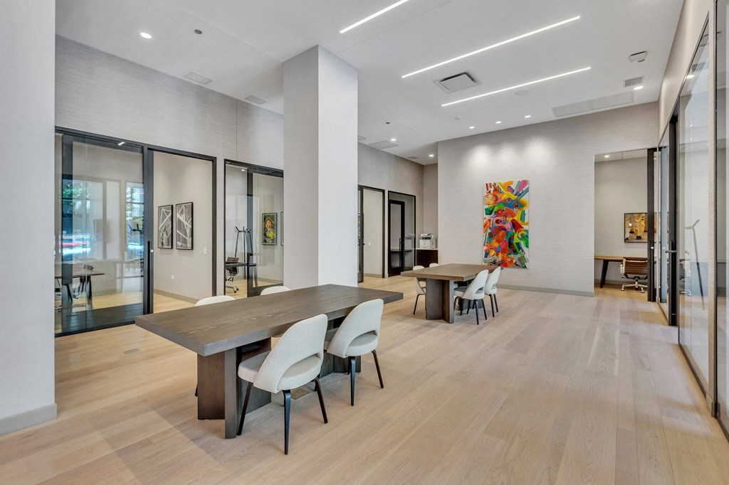 a large room with a table and chairs and a painting on the wall