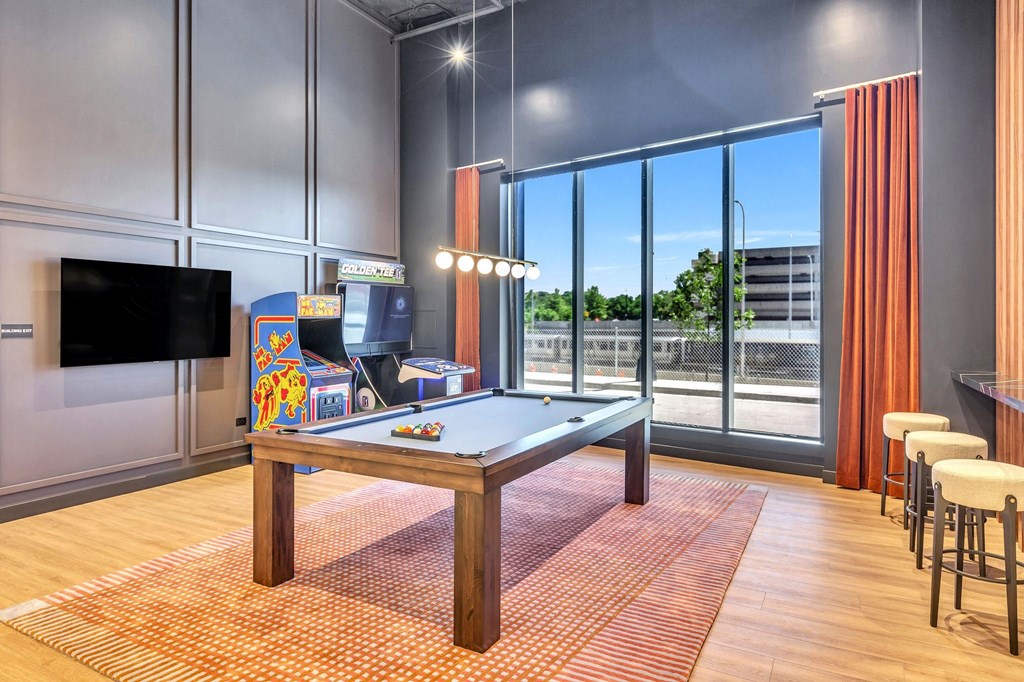 a games room with a pool table and a television