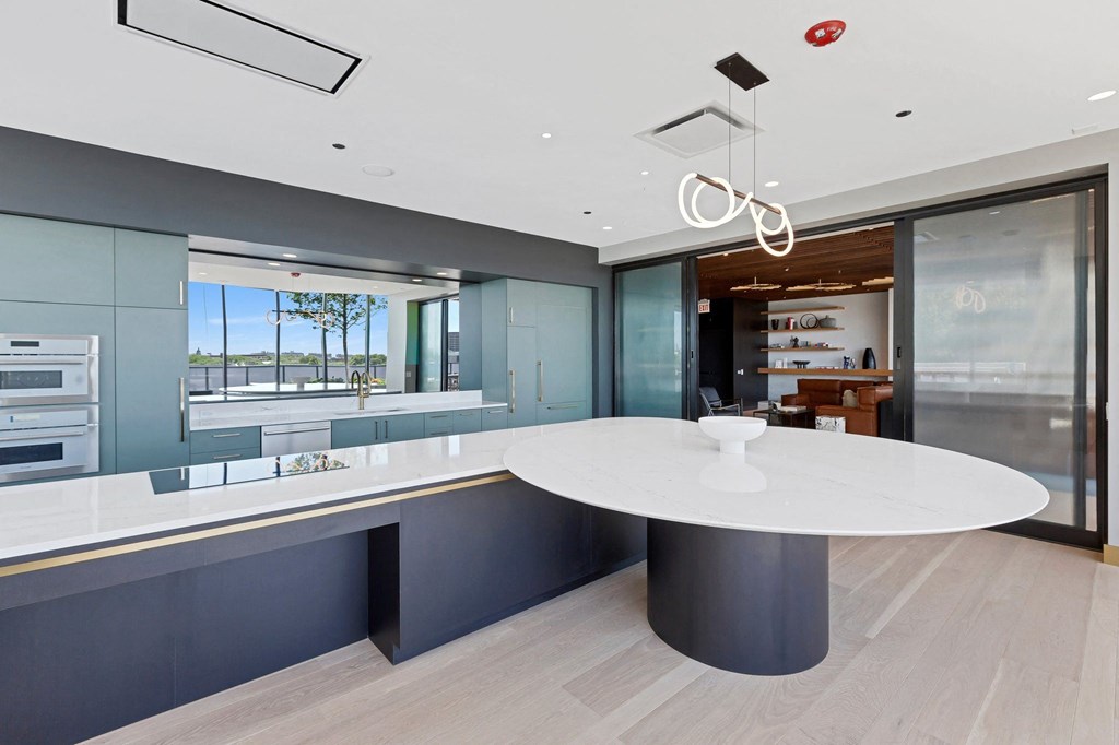 a large kitchen with a white counter top and blue walls