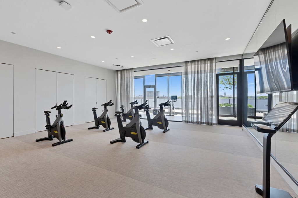 a workout room with exercise bikes and a view of the city
