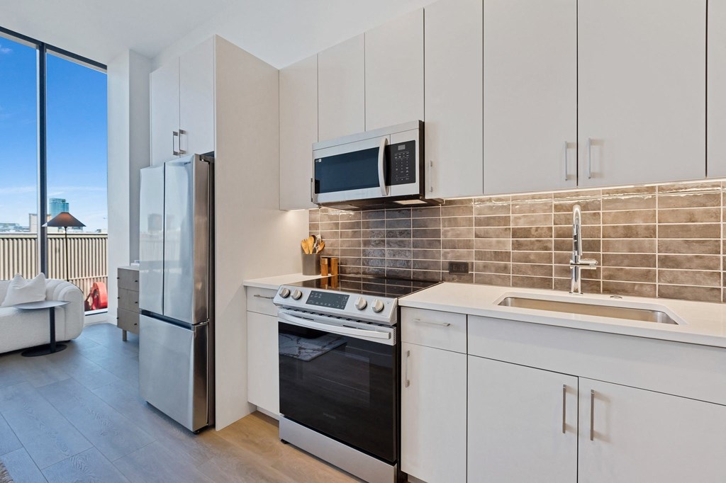 a kitchen with white cabinets and a sink and a refrigerator