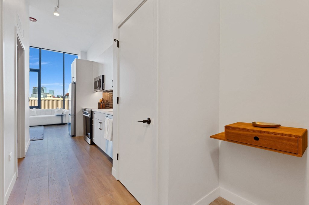 a kitchen with white walls and a white door and a window