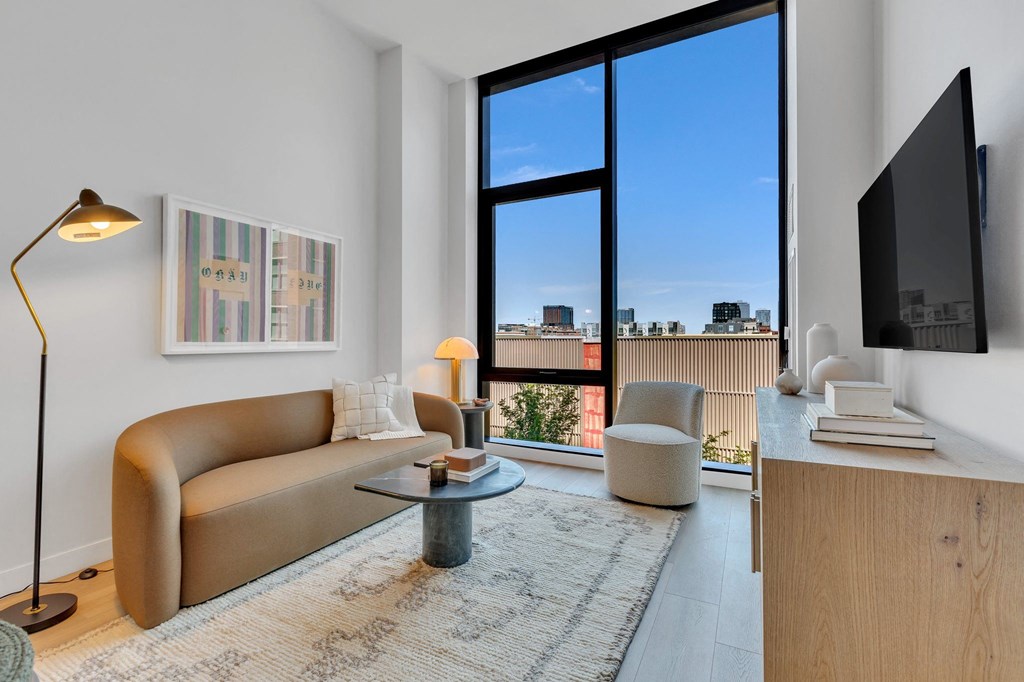 a living room with a couch and two chairs and a large window