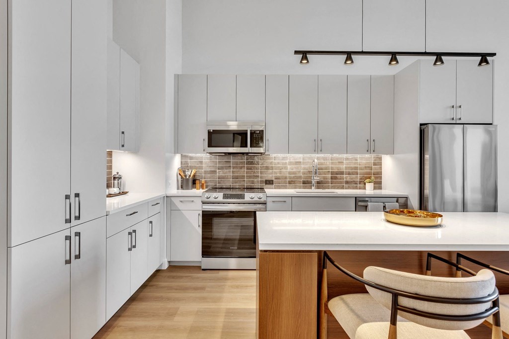 a kitchen with white cabinets and stainless steel appliances