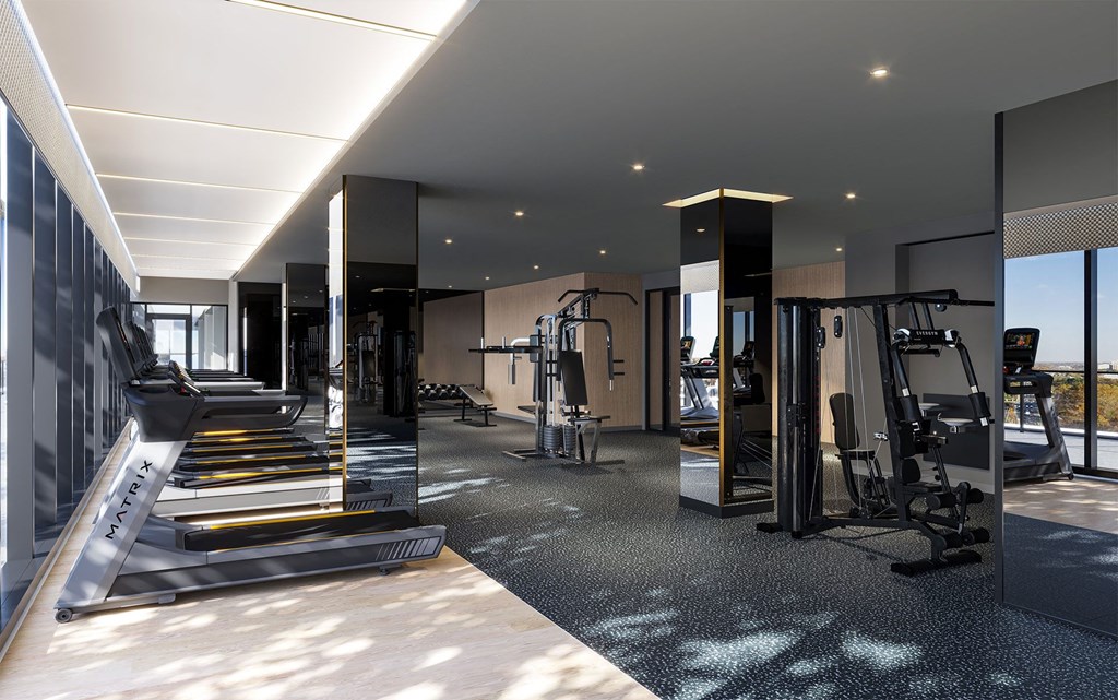 a gym with weights and cardio equipment on the floor and glass walls