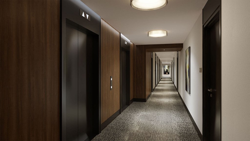 a row of elevators and doors in a hotel hallway