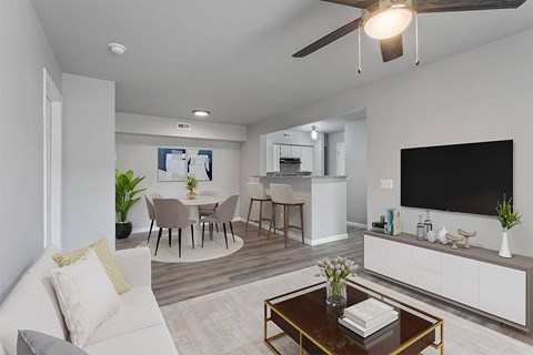A modern living room with a white couch, a coffee table, and a flat-screen TV.