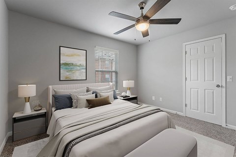 A bedroom with a large bed and a ceiling fan.
