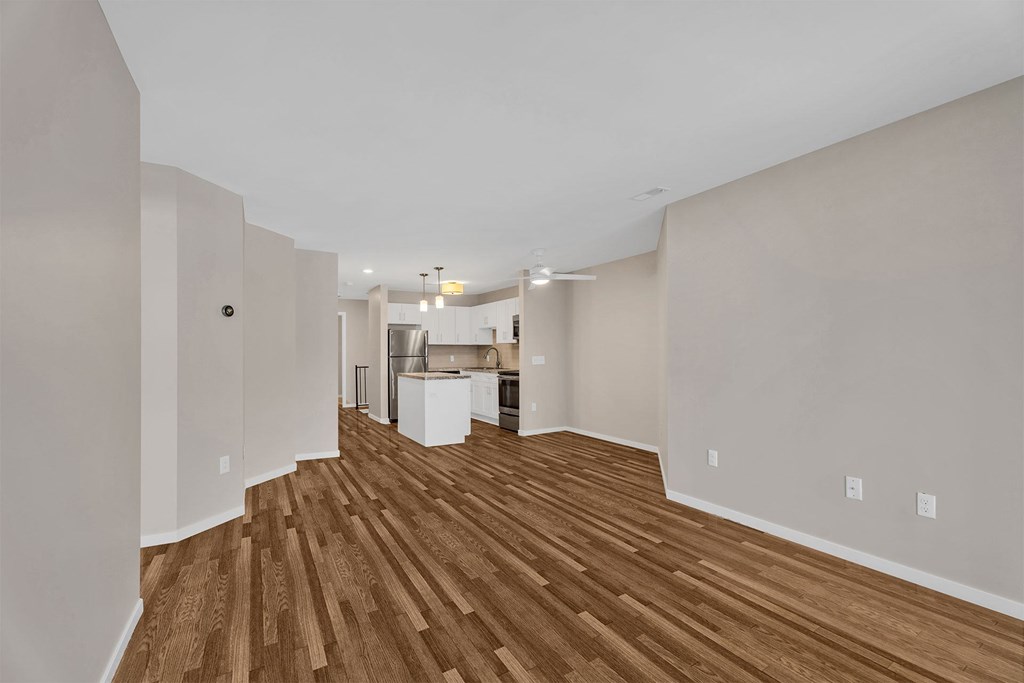 A room with wooden flooring and white walls.