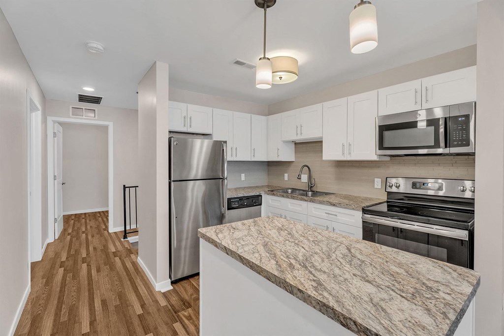 A kitchen with a refrigerator, oven, and microwave.