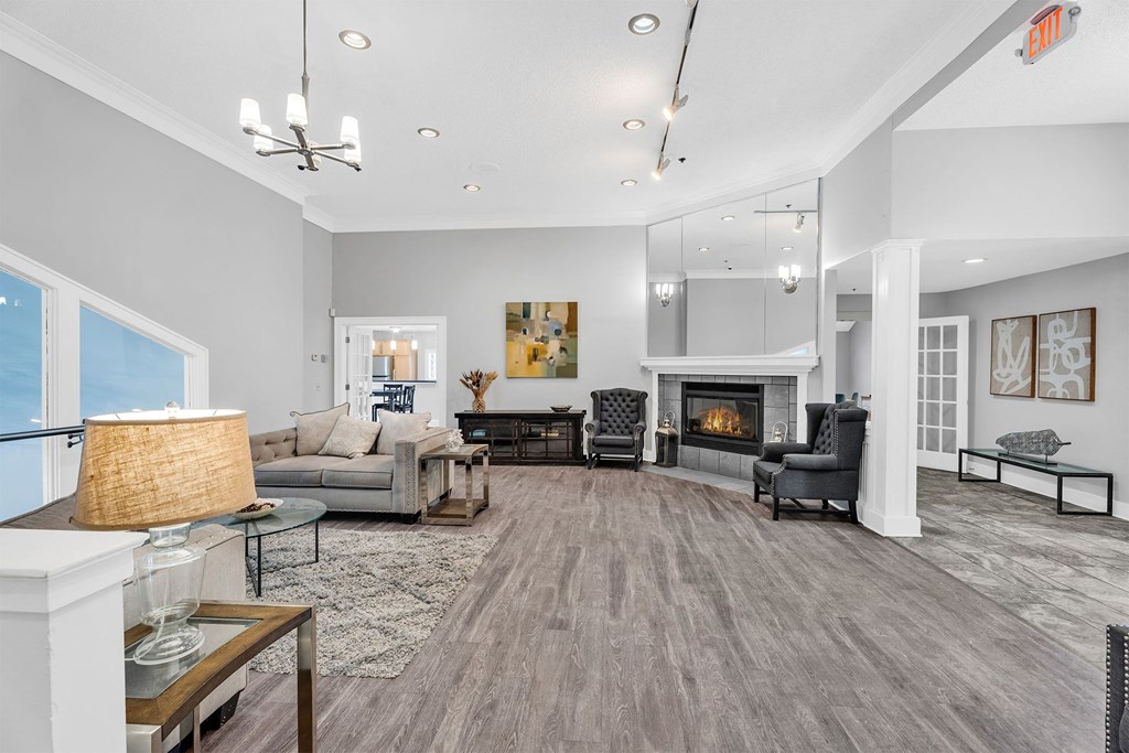 A spacious living room with a fireplace and a large painting on the wall.