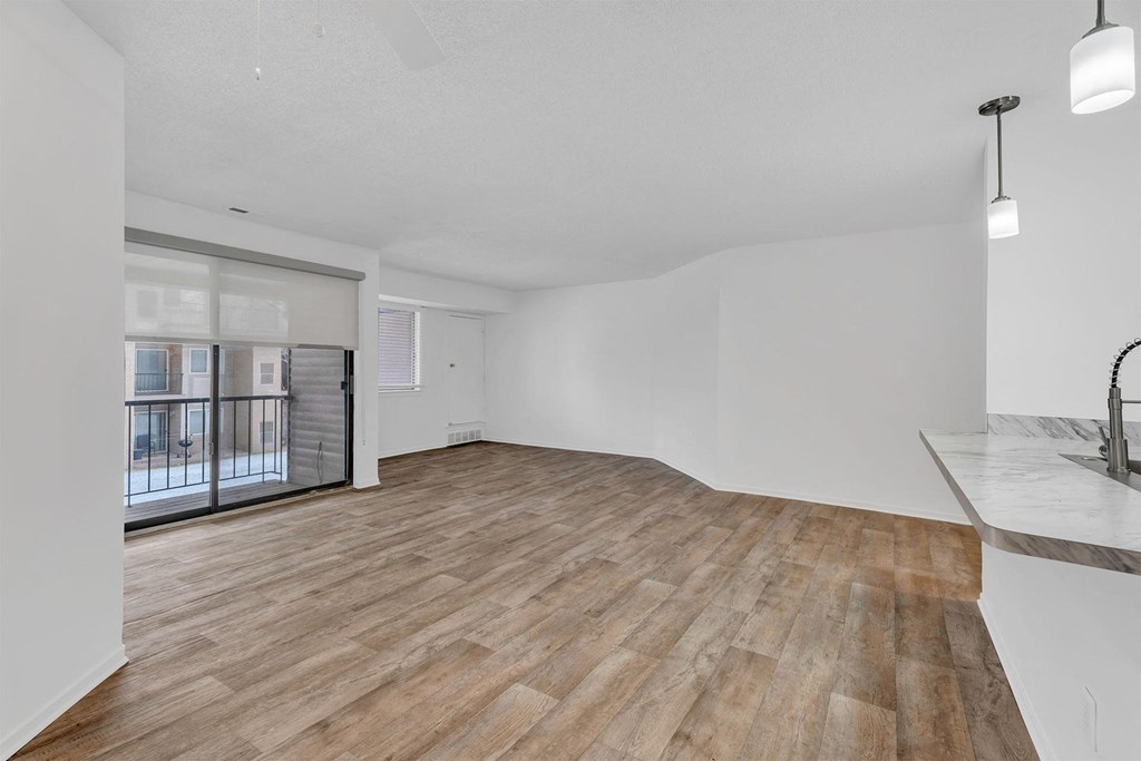 A spacious room with wooden flooring and a marble countertop.
