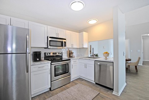 A kitchen with white cabinets and stainless steel appliances.