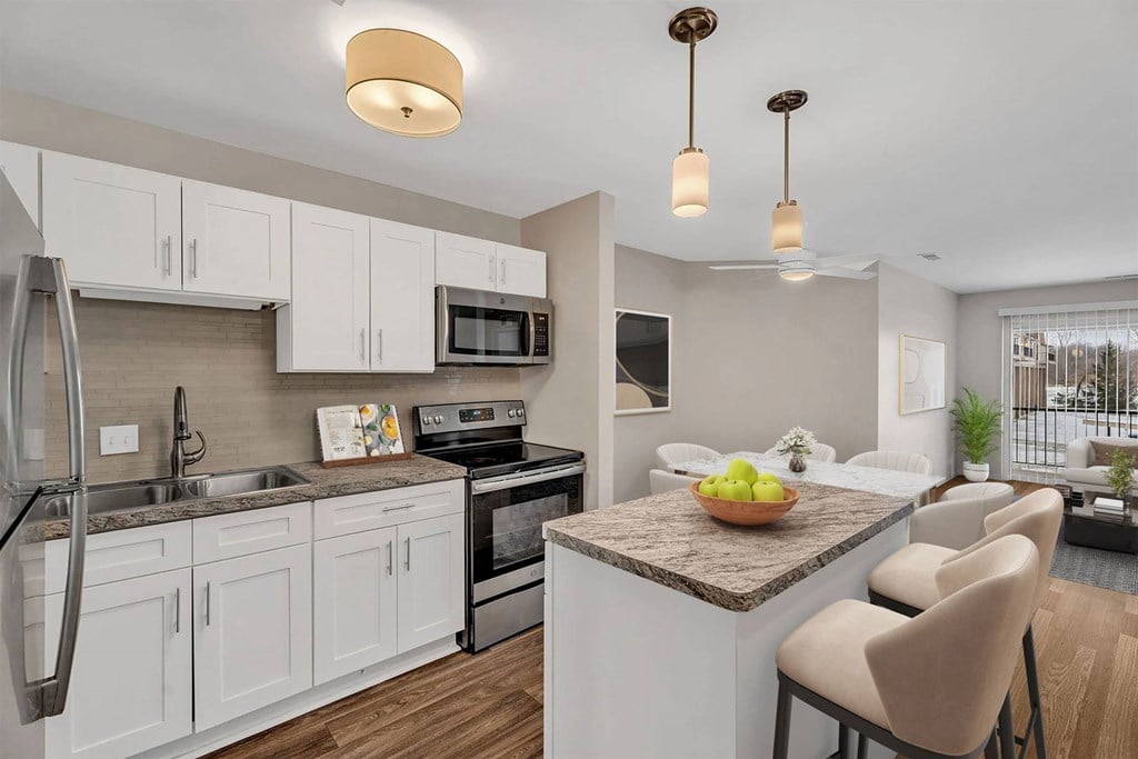 A kitchen with white cabinets and a granite countertop.
