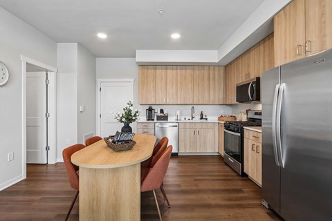 A modern kitchen with a wooden table and chairs.