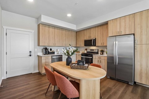 A kitchen with a table and chairs in the middle of it.