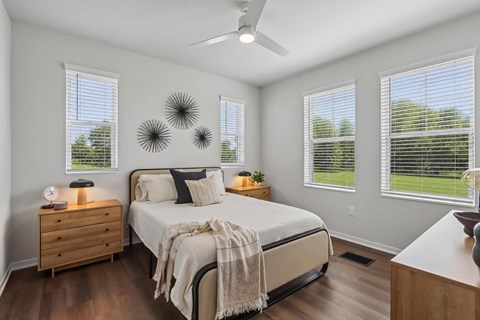 A bedroom with a bed, nightstands, and a ceiling fan.