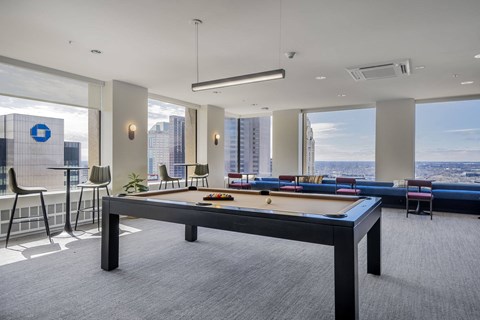 A pool table in a room with a view of the city.