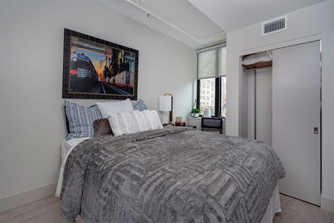 A bedroom with a large bed and a painting above it.