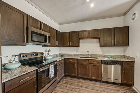 a kitchen with wooden cabinets and stainless steel appliances