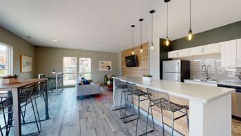 a kitchen and living room with a large white island with a white countertop