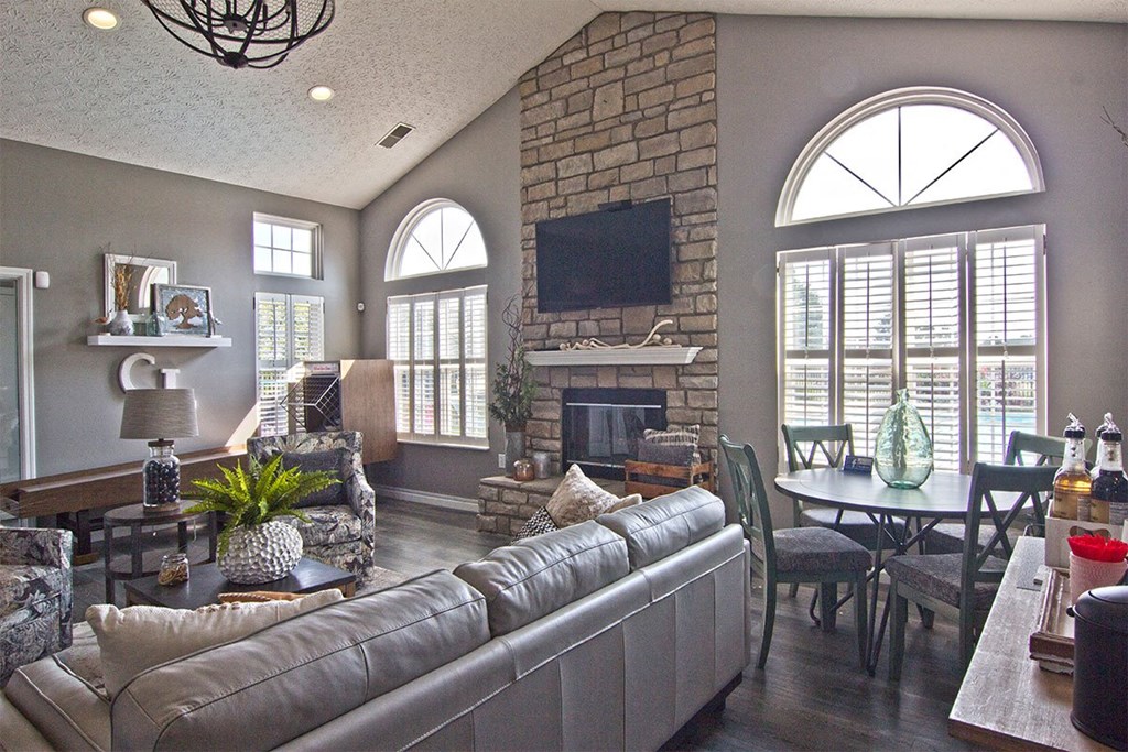 a large living room with a stone fireplace and couches