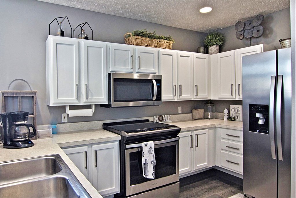 a kitchen with white cabinets and stainless steel appliances