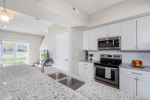 A kitchen with granite countertops and stainless steel appliances.