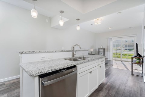 A kitchen with white cabinets and a granite countertop.