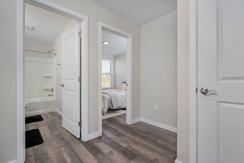 A bedroom with a bed, a window, and a door.