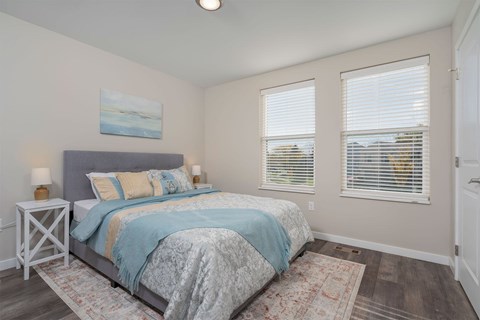 A bedroom with a bed, nightstand, and window.