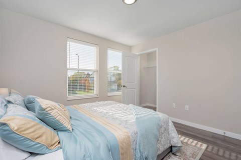 A bedroom with a bed, pillows, and a blanket.