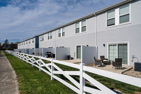 A long building with a white fence in front.