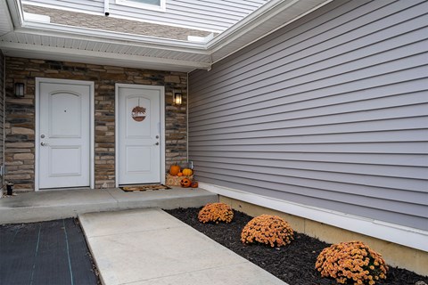 A house with a white door and a stone wall.