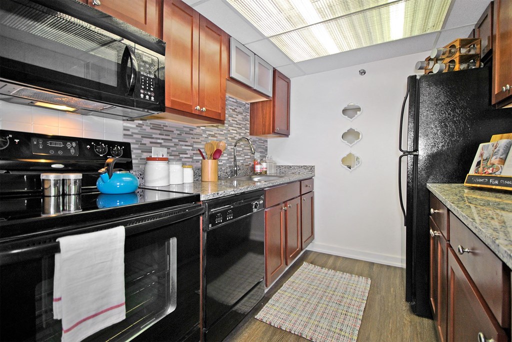a kitchen with black appliances and wooden cabinets