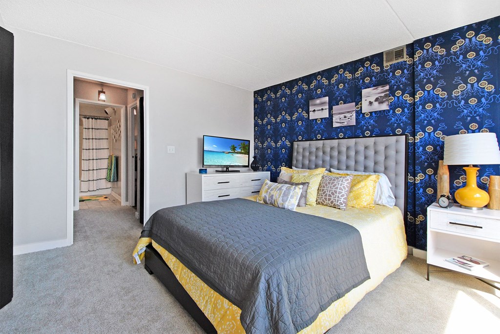 a bedroom with a bed and a blue and yellow wallpaper