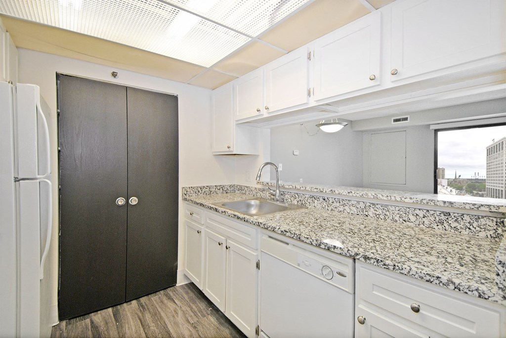 a kitchen with granite counter tops and white cabinets
