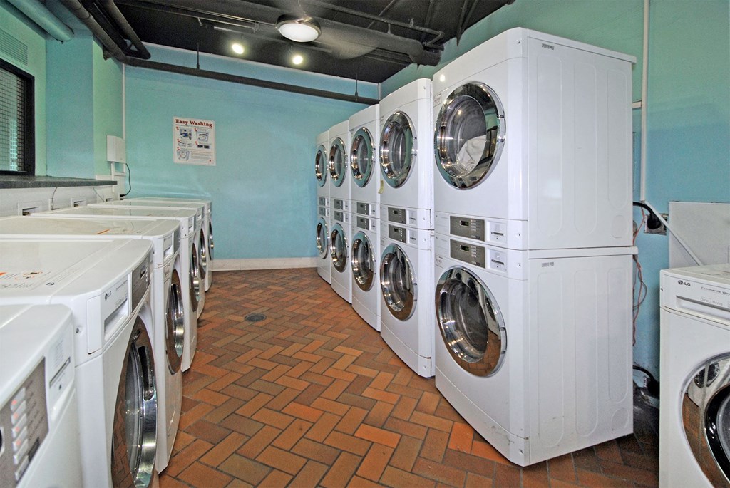 a laundry room filled with white washers and dryers