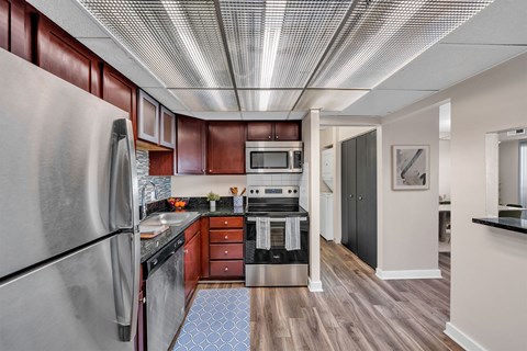A kitchen with a refrigerator, microwave, oven, and sink.