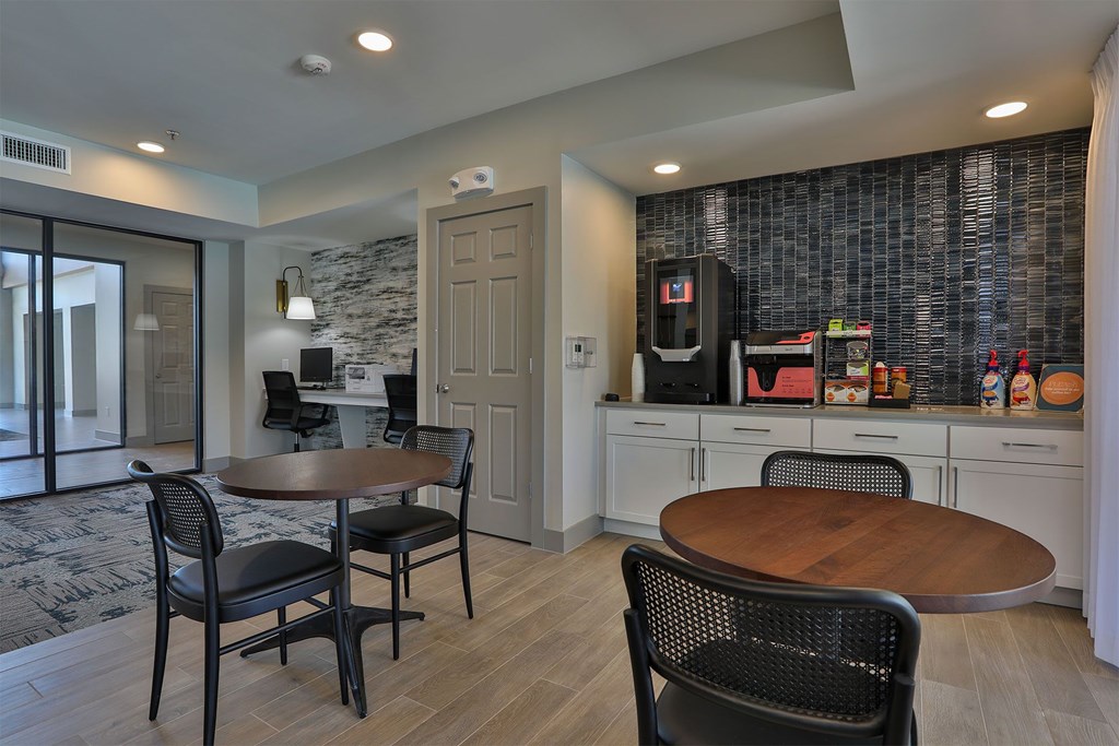 A kitchen with a table and chairs in front of a wall with a stone pattern.