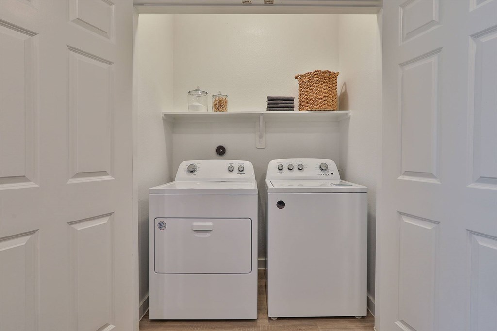 A white laundry room with a washer and dryer.