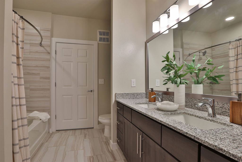 A bathroom with a white door and striped shower curtain.