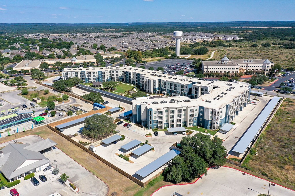 An aerial view of a large building complex with a parking lot in front.