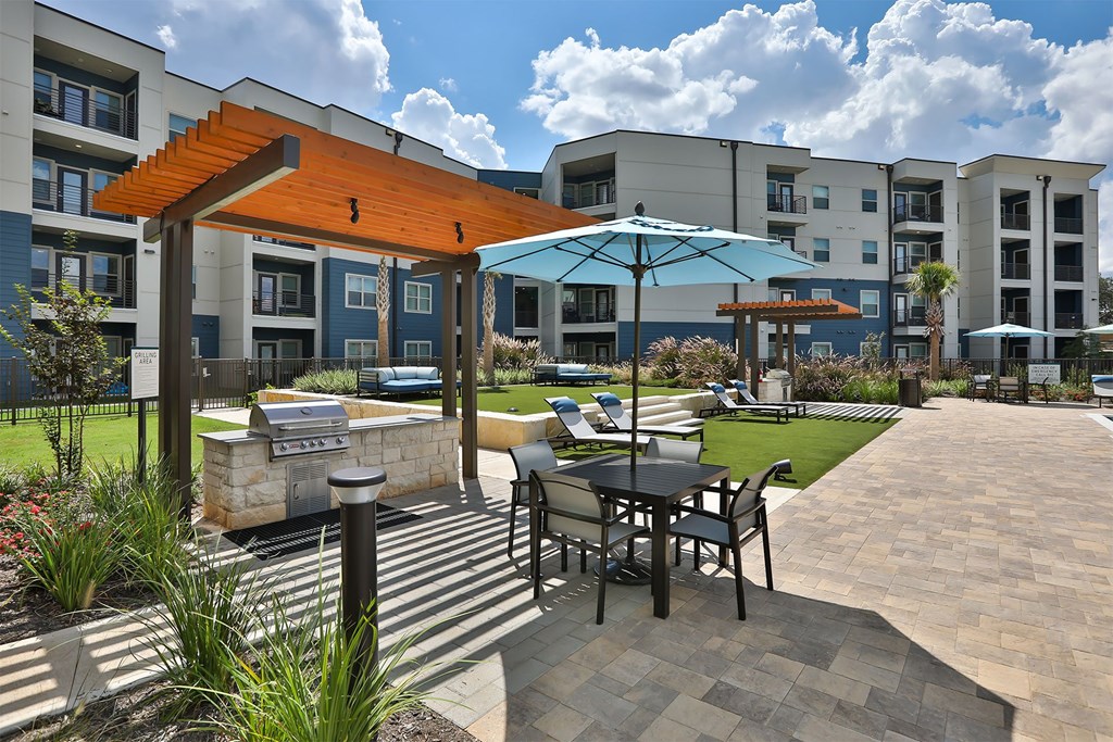 A patio with a table and chairs is surrounded by apartment buildings.