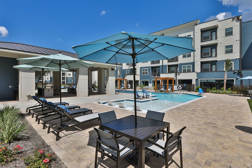 A poolside area with chairs and umbrellas.