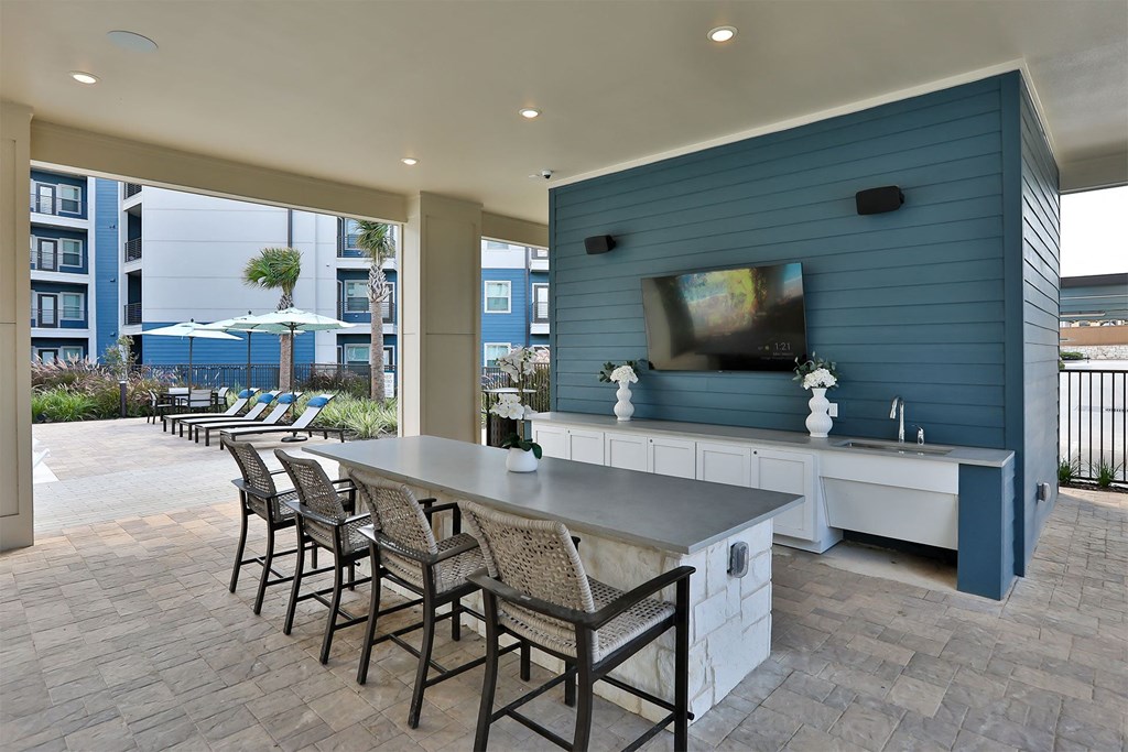 A patio with a bar and chairs.